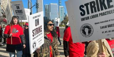 Photo of Columbia College Faculty Union members on the picket line. Signs read "Columbia Faculty On Strike. Unfair Labor Practices. Illinois Federation of Teachers, Local 6602. IFT, AFT, AFL-CIO""