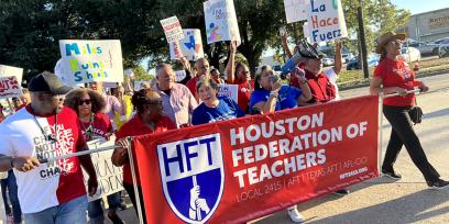 Photo of AFT President Randi Weingarten, HFT President Jackie Anderson,and HFT members marching with banner that reads 'Houston Federation Teachers. Local 2415 | AFT | TEXAS AFT | AFT-CIO"