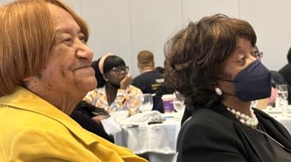 La copresidenta del PSRP, Shelvy Abrams (derecha), bajó del podio para sentarse con Lorretta Johnson mientras las dos eran honradas.