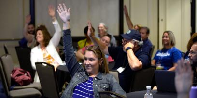 Foto de los participantes levantando la mano en AFT TEACH 2023