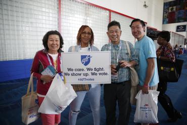 Photo from Convention 2024. One member holds a sign that reads "We care. We fight. We show up. We vote. #AFTvotes"
