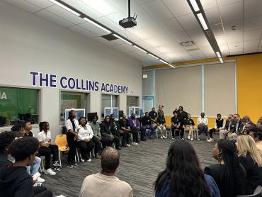 students and teachers gathered in a circle of chairs