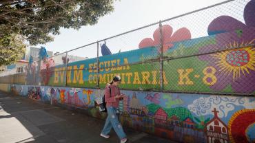 student walking in front of school mural