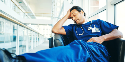 Tired medical professional sleeping in hospital lounge stock photo. PHOTO CREDIT: GettyImages/Dean Mitchell