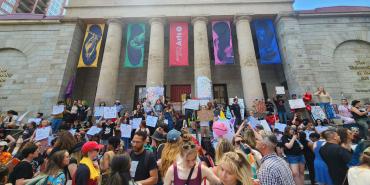 Photo of large group of students and community members rallying on the steps of the University of the Arts in Philadelphia 