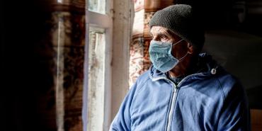 Man in medical mask looks to the left