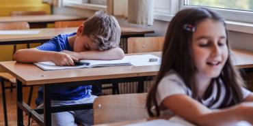 exhausted elementary school student asleep at desk