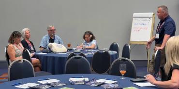 Texas AFT President Zeph Capo leads a roundtable discussion and takes notes on a flip chart.&nbsp;