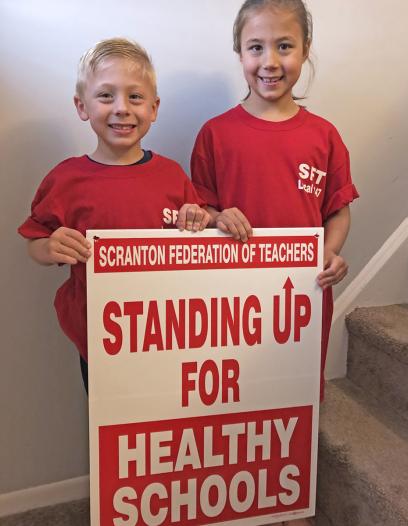 loftus children stand with sign