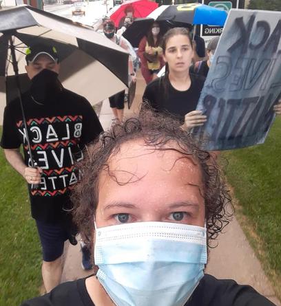 Brandon Thomas and two colleagues attend a BLM march with signs