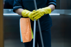 Foto de primer plano de un trabajador de limpieza centrado en manos y materiales enguantados