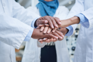 Photo of health professionals with stacked hands
