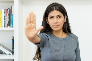 Foto de mujer con la mano en alto haciendo un gesto de "parar"