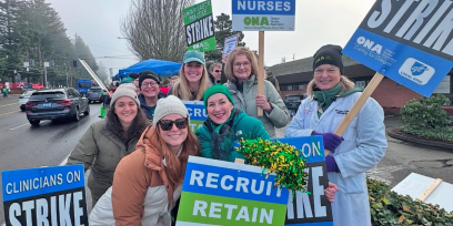 Group of striking clinicians pose with picket signs